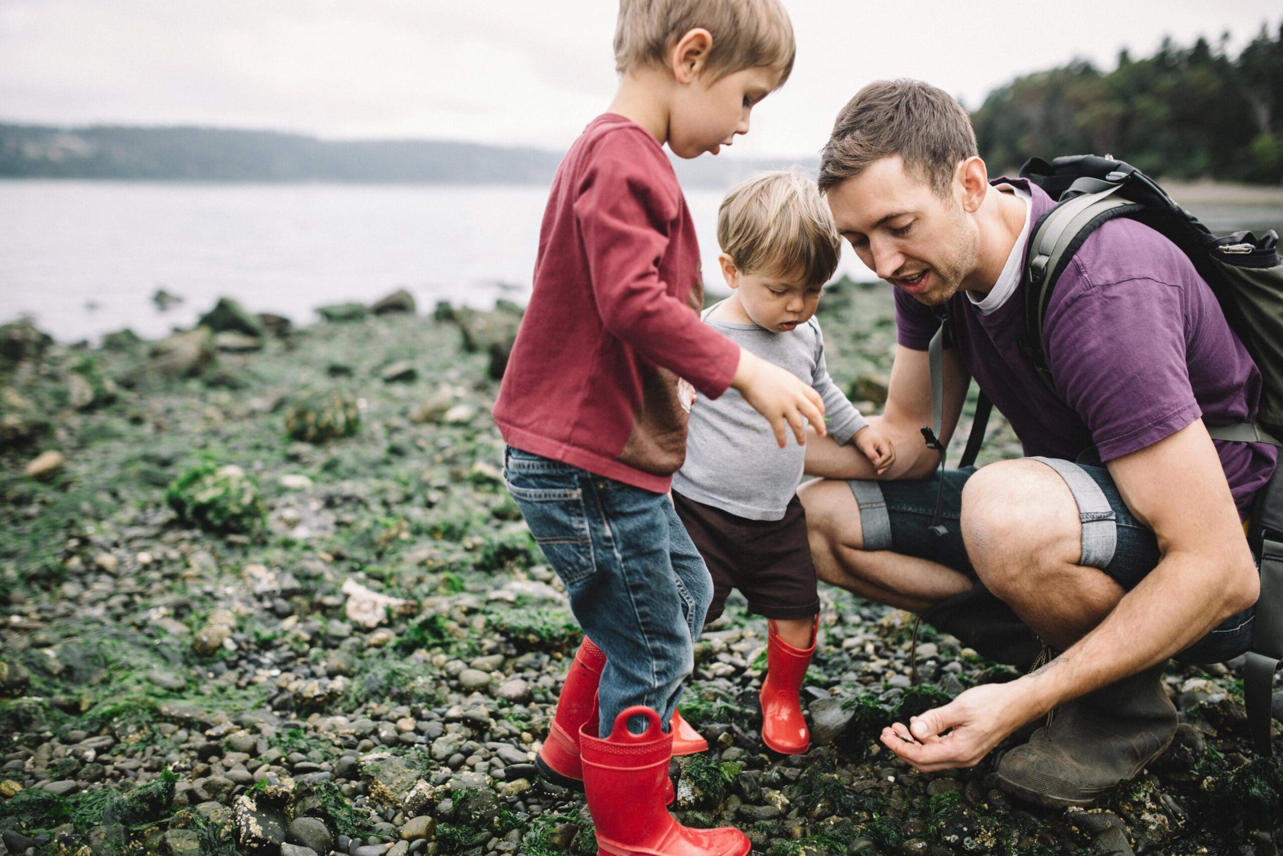 Father and Sons Exploring Rocky Beach
