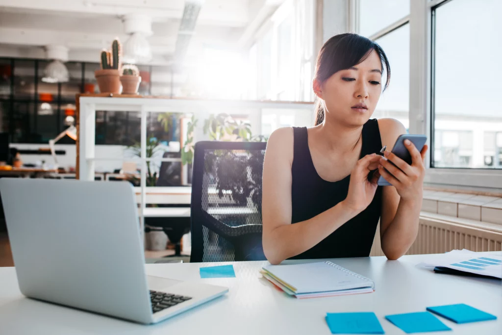 Young businesswoman using mobile phone at work