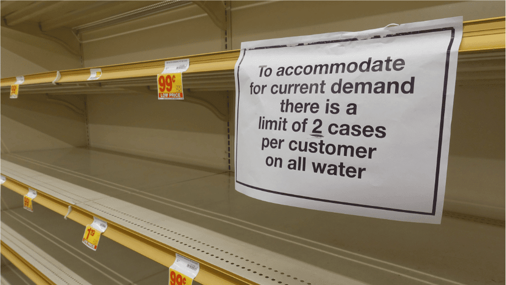 Demand Surge Example: Empty Store Shelves. Sign read: to accommodate for current demands, there is a limit of 2 cases per customer on all water