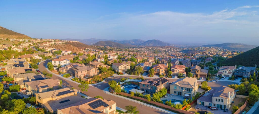 Find the most affordable earthquake insurance in California. Entire view of a residential area from Double Peak Park in San Marcos, California. Suburban community near the mountains against the sky background.