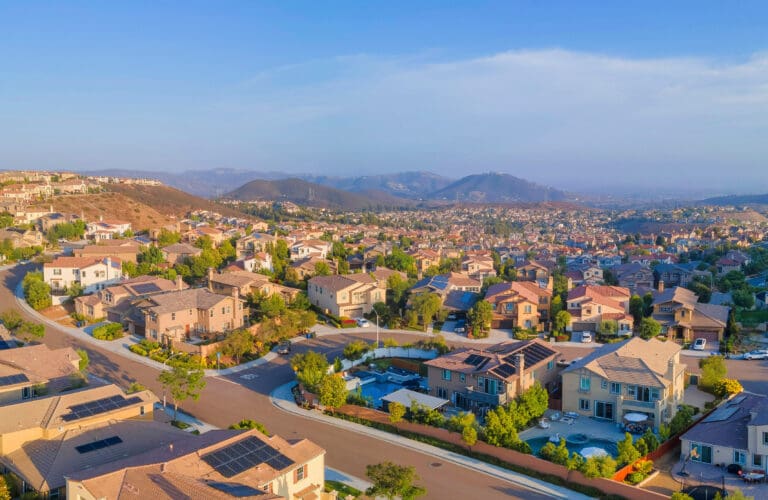 Find the most affordable earthquake insurance in California. Entire view of a residential area from Double Peak Park in San Marcos, California. Suburban community near the mountains against the sky background.