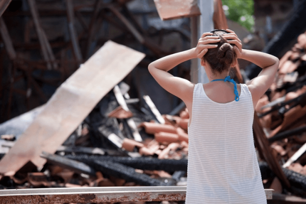 homeowner in front of damaged home